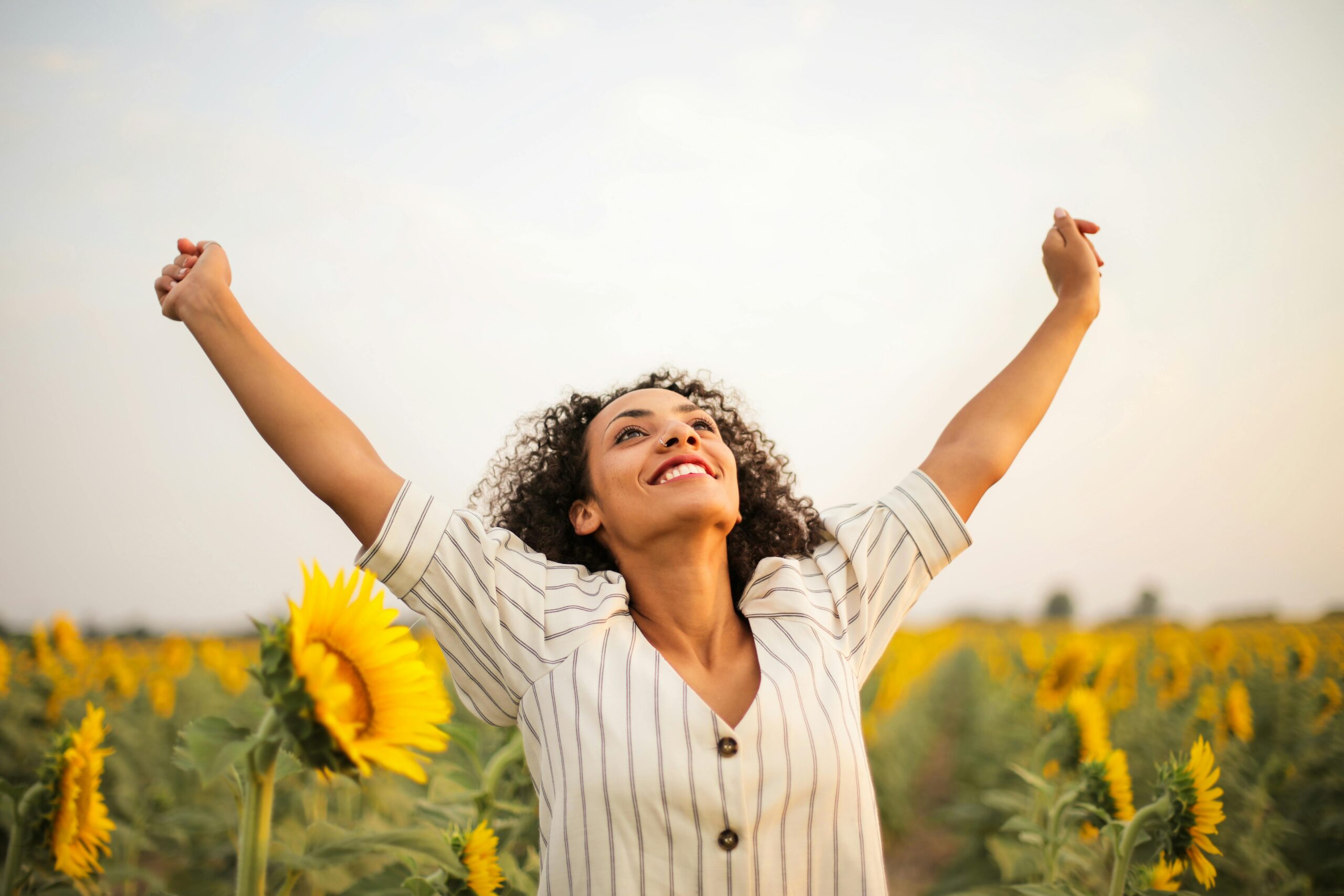 beautiful-woman-free-raised-hands-field-of-flowers