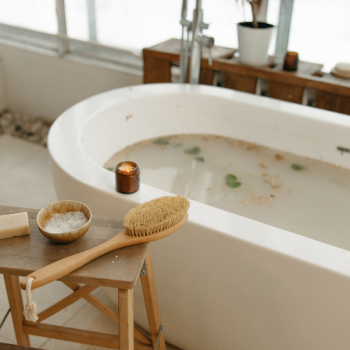 ivory soaking tub with epsom salts, dry brushing and candle for detox