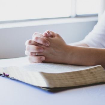 praying thankful hands folded with Bible to aid in detox